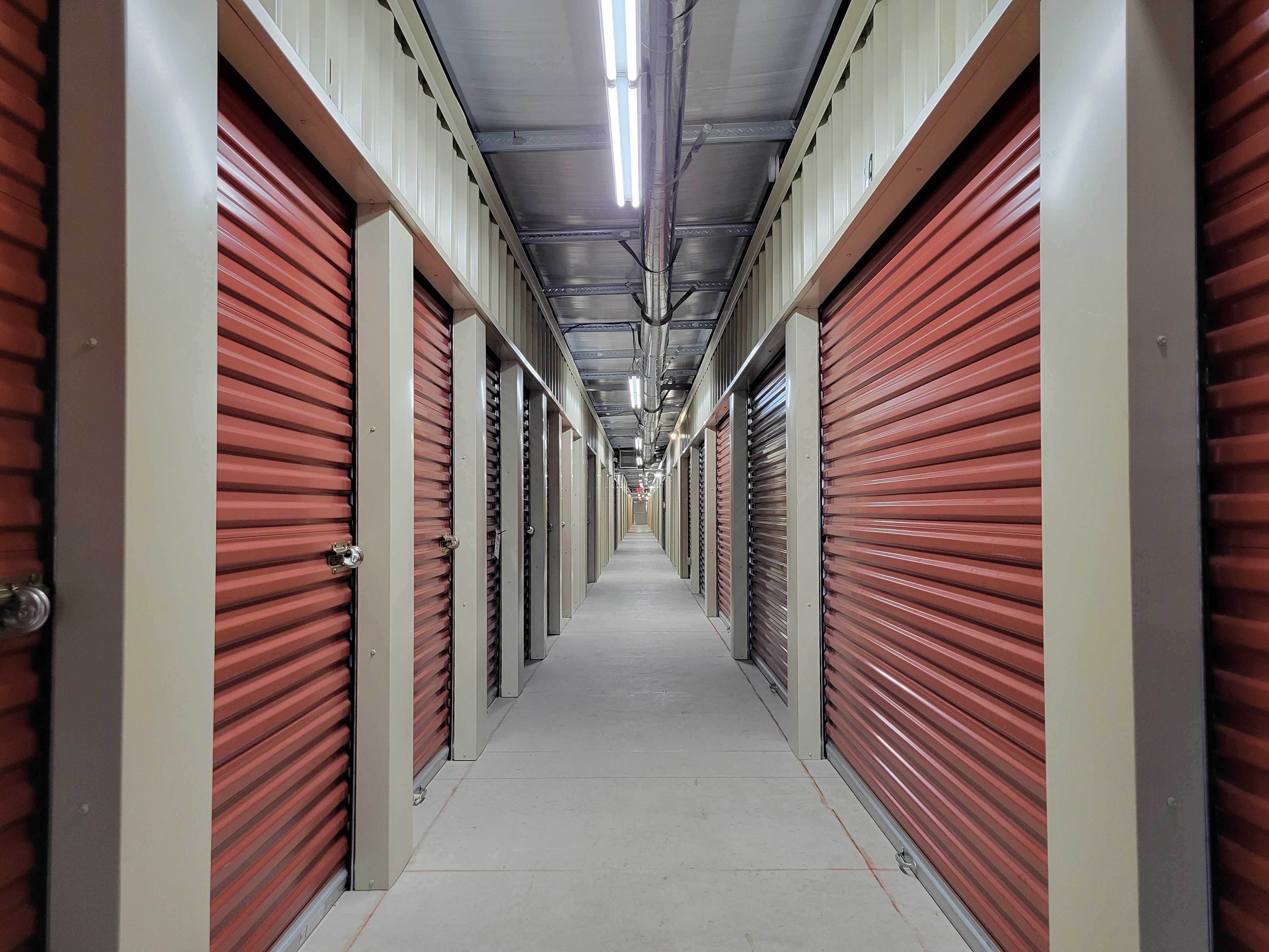 Interior climate-controlled storage units with red roll-up doors at Royse City storage facility